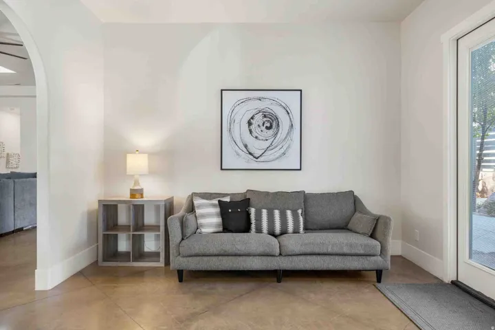 Arched entryway, light-toned walls, and durable concrete flooring
