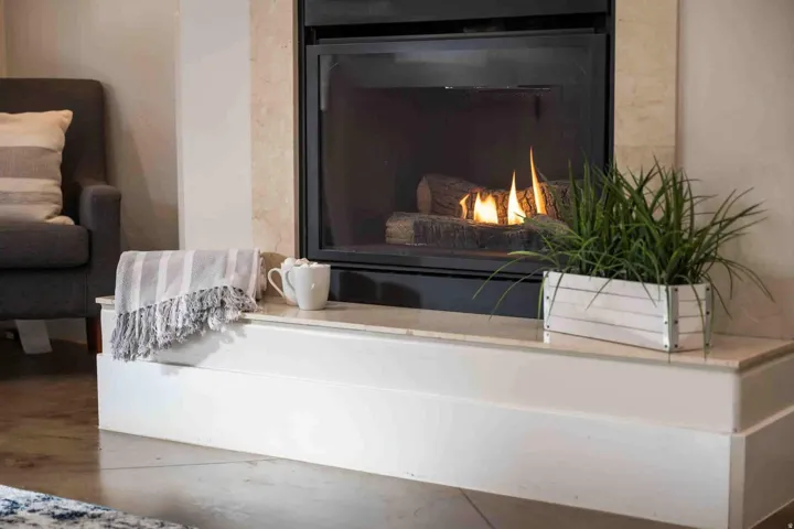 Fireplace featuring a stone surround, black glass doors, and a built-in hearth