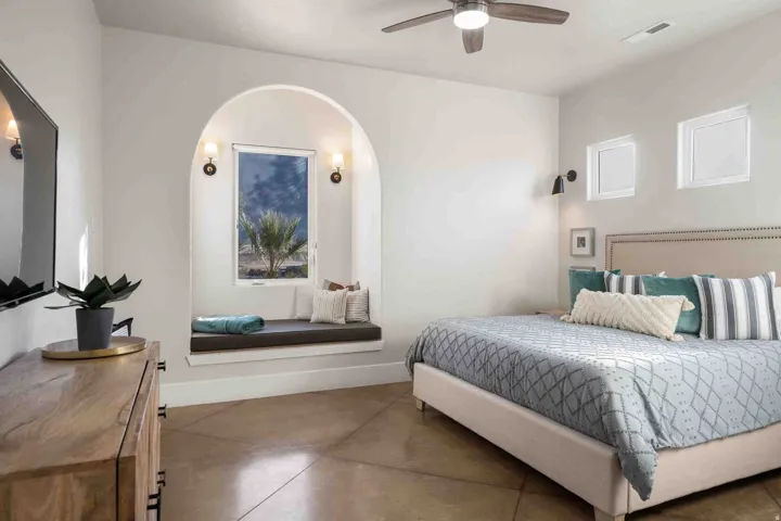 Arched window niche with integrated bench seating, illuminated by sconce lighting