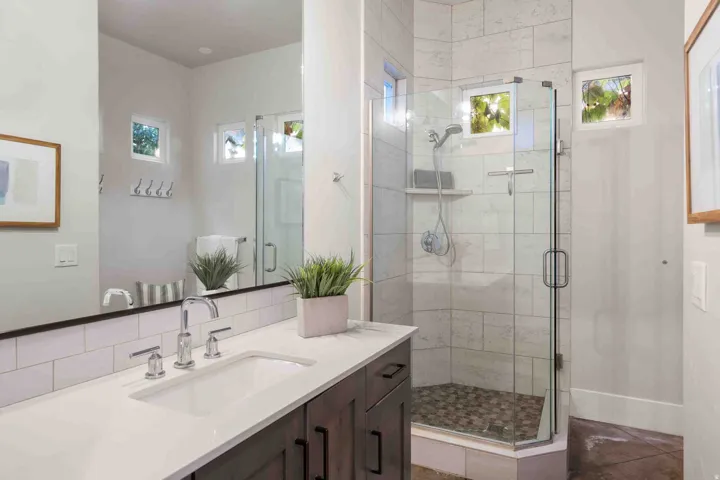 Integrated vanity with an undermount sink, a chrome faucet, and dark wood-finish cabinetry