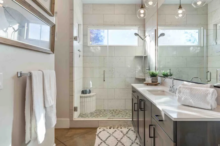 Walk-in shower with a built-in bench, glass enclosure, and tiled walls