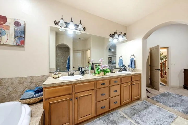 Dual vanity with integrated sinks, wood-finish cabinetry, and a light-toned countertop