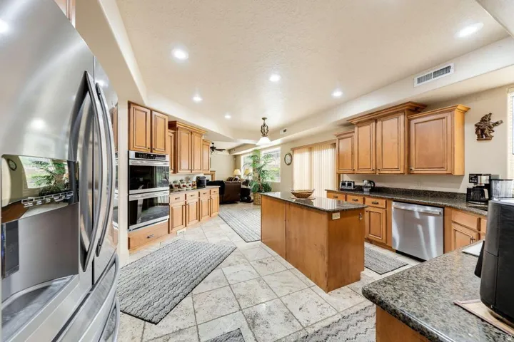 Full kitchen featuring wood cabinetry, stainless steel appliances, a center island, and recessed lighting