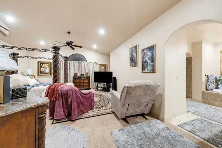 Arched entryway to a room with vaulted ceilings and recessed lighting