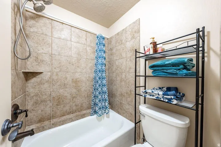 Bathtub with tiled surround, showerhead, and bronze-finish fixtures
