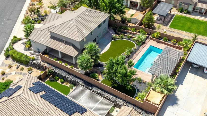 Terracotta tile roofing, private swimming pool, artificial turf landscaping, covered patio, and mature palm trees