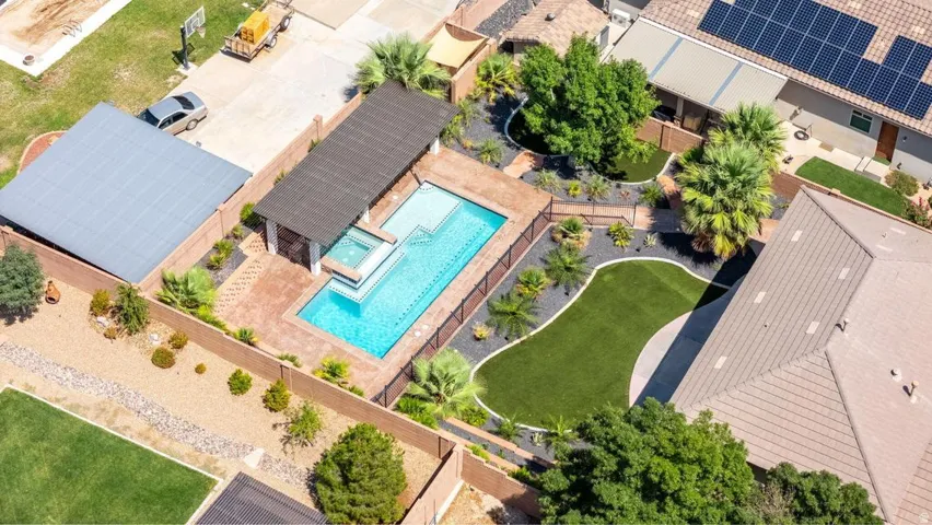 Resort-style backyard featuring a swimming pool, integrated spa, and an attached covered patio