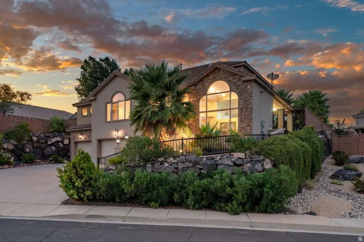 Stucco exterior with stone accents, featuring a prominent arched window and two-car garage