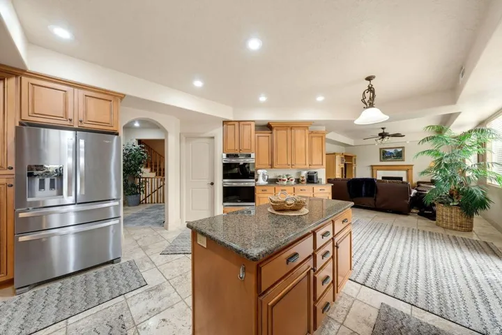 Kitchen featuring a center island with a stone countertop, wood cabinetry, and stainless steel appliances