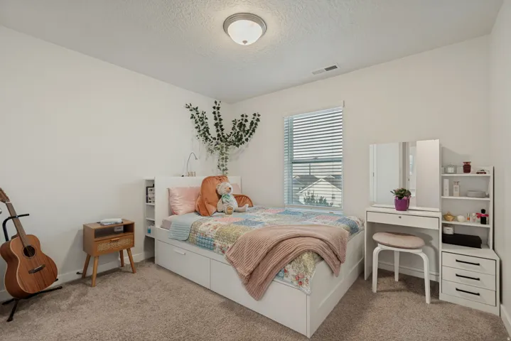 White walls, carpeted flooring, and a single window with blinds