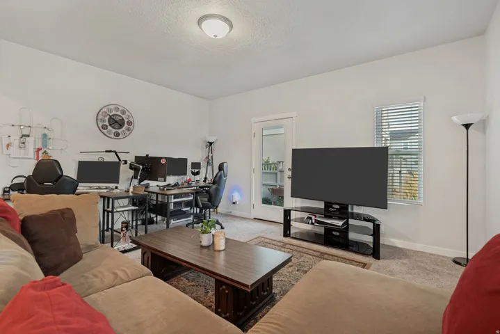 Recessed ceiling light fixture, neutral wall finishes, carpeted flooring, white trim, and a glass-paneled door