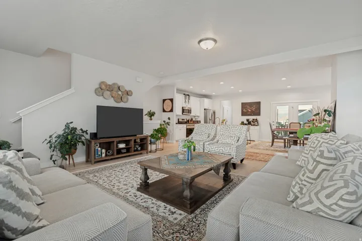 Spacious living area featuring light wood-finish flooring, white walls, and an open layout