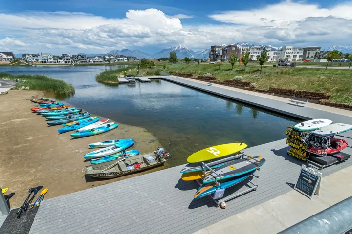 Waterfront setting with a long dock, surrounding residential properties, and distant mountain ranges