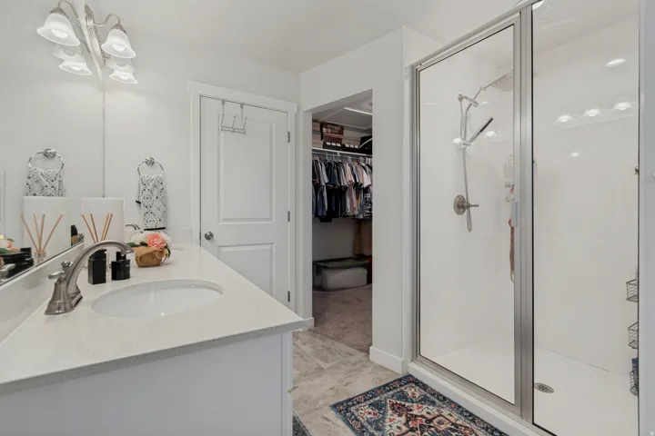 Walk-in shower with clear glass enclosure and brushed nickel fixtures