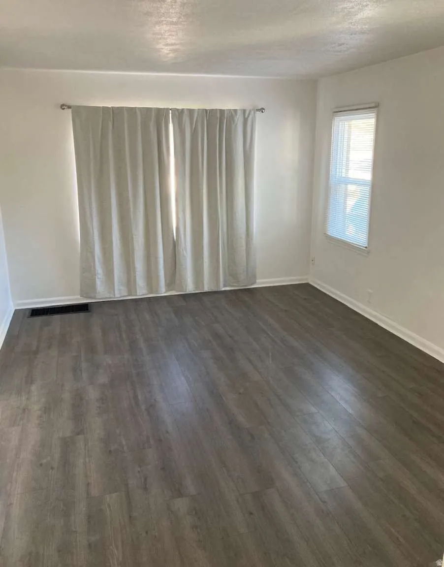 Wood-finish flooring throughout, white walls, and multiple windows