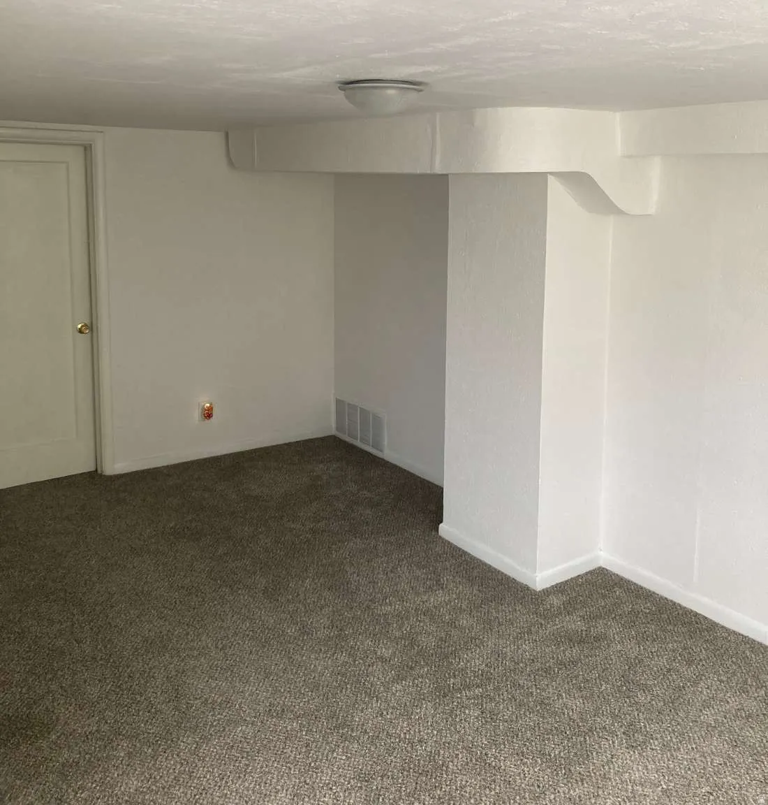 Textured wall finish, white interior door, wall-to-wall carpeting, overhead flush mount lighting, and white trim throughout