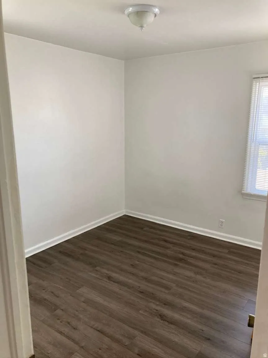 Wood-finish flooring, white walls, and a ceiling-mounted light fixture