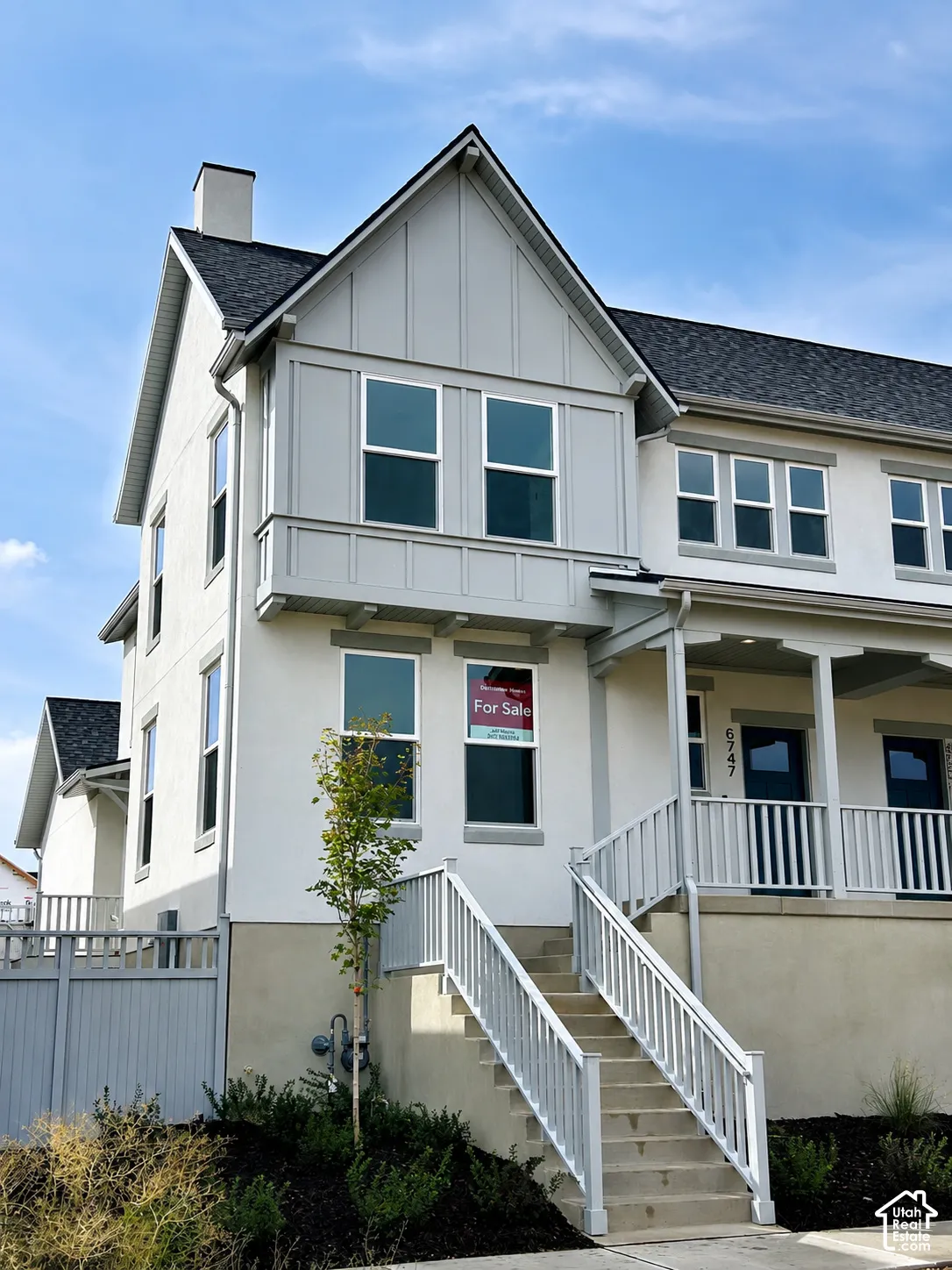 Stucco exterior with a gable roofline, featuring an integrated chimney and a covered porch entry