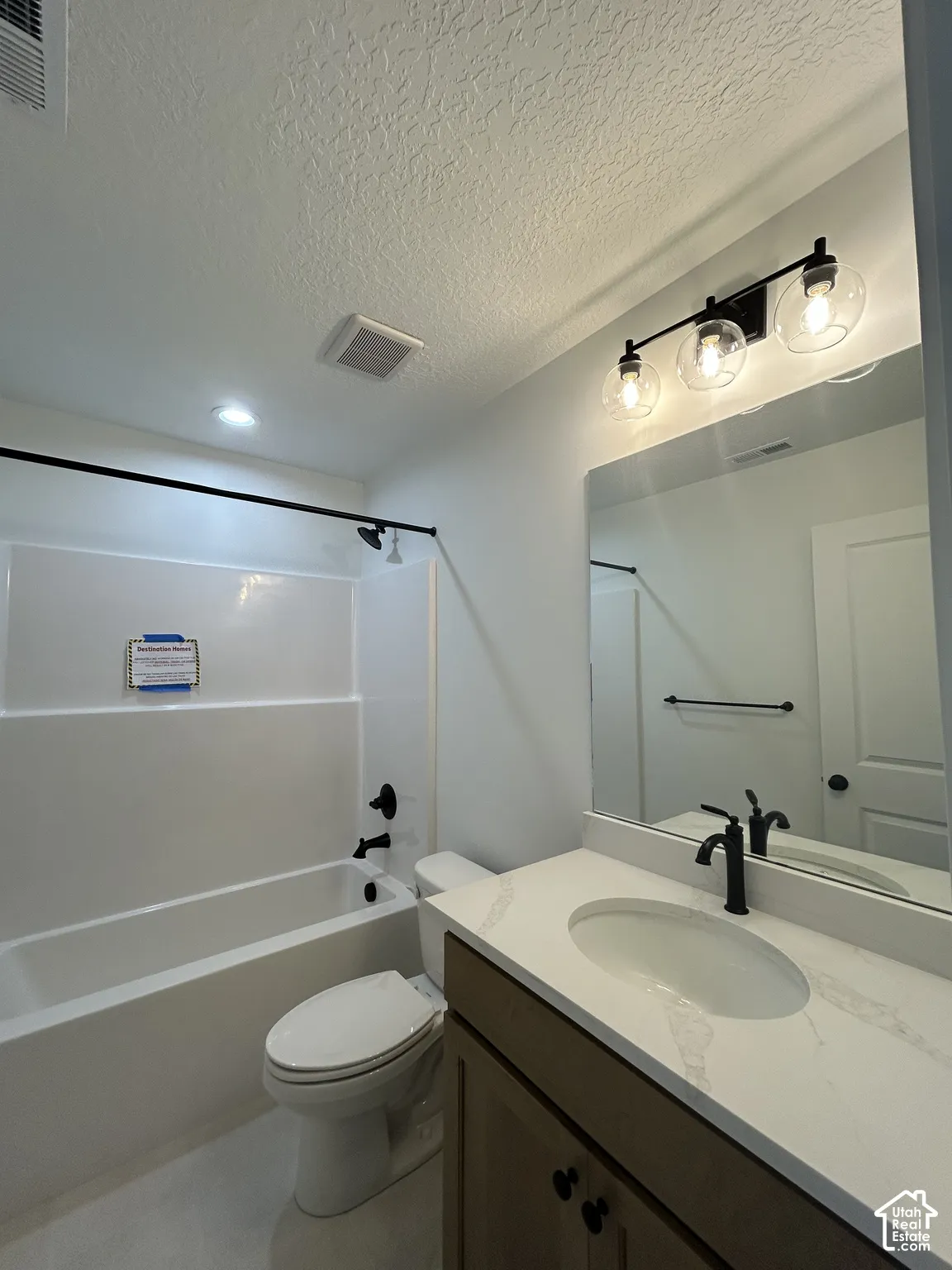 Modern vanity with a light-toned countertop, oval undermount sink, and matte black faucet