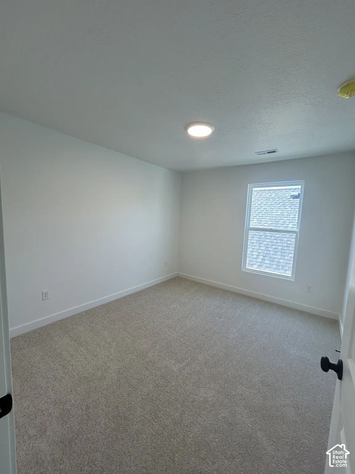 Recessed ceiling lighting illuminates the carpeted flooring