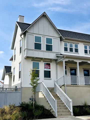 Stucco exterior with a gable roofline, featuring an integrated chimney and a covered porch entry