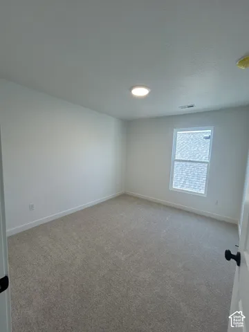 Recessed ceiling lighting illuminates the carpeted flooring