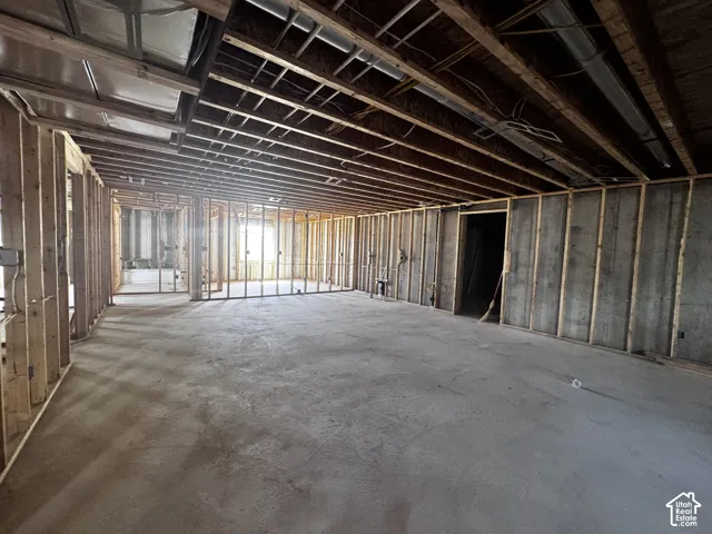 Unfinished interior space with exposed wood framing, concrete flooring, and visible ductwork