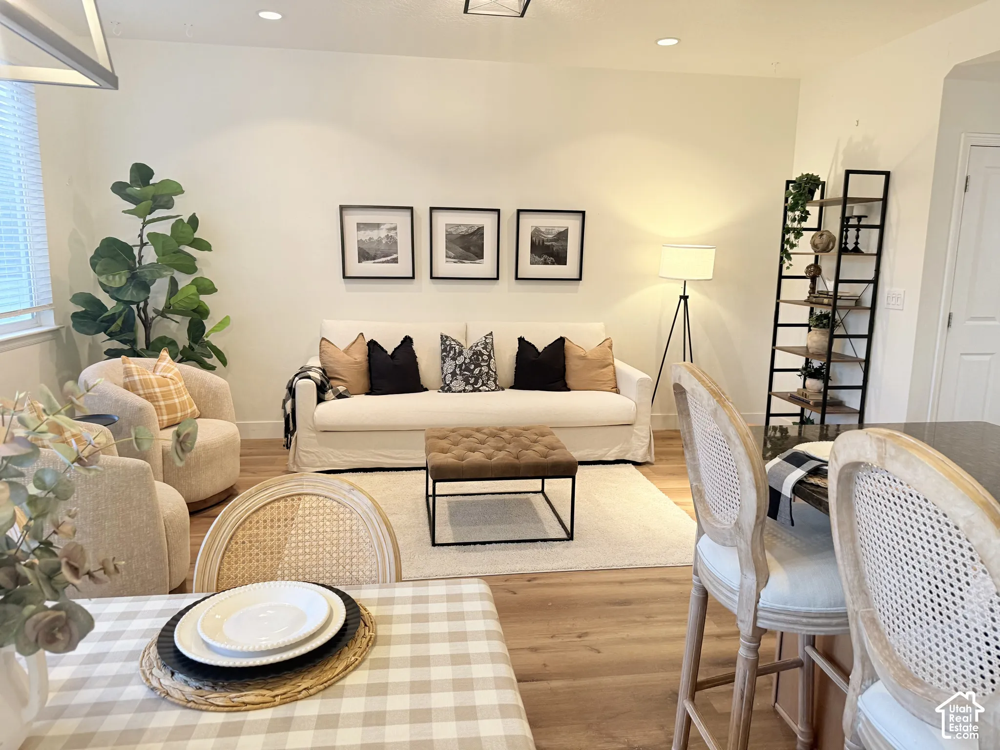 Recessed lighting illuminating the living area, wood-finish flooring, and white window blinds