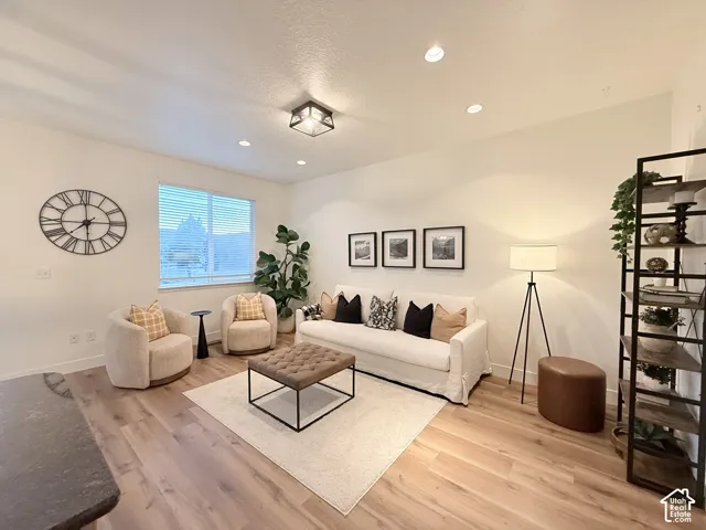 Recessed ceiling lighting, wood-finish flooring, and a large window with blinds