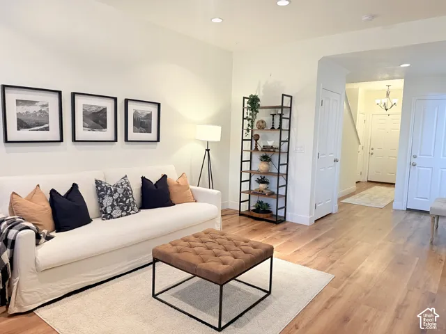 Recessed ceiling lighting, wood-finish flooring, white painted walls, and a white paneled door