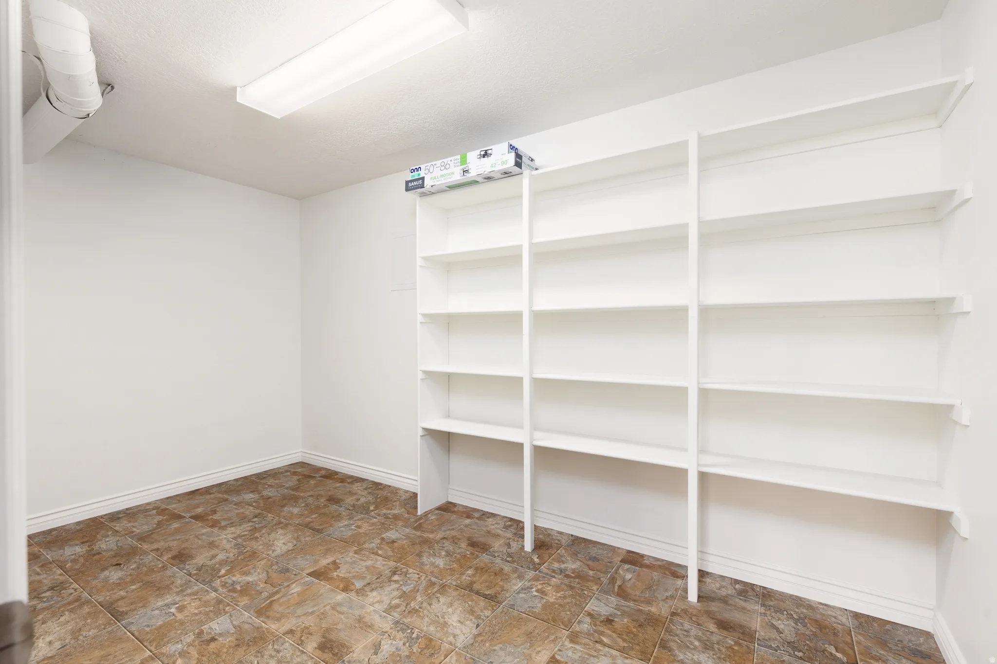 Built-in shelving units, recessed ceiling light, and tiled flooring