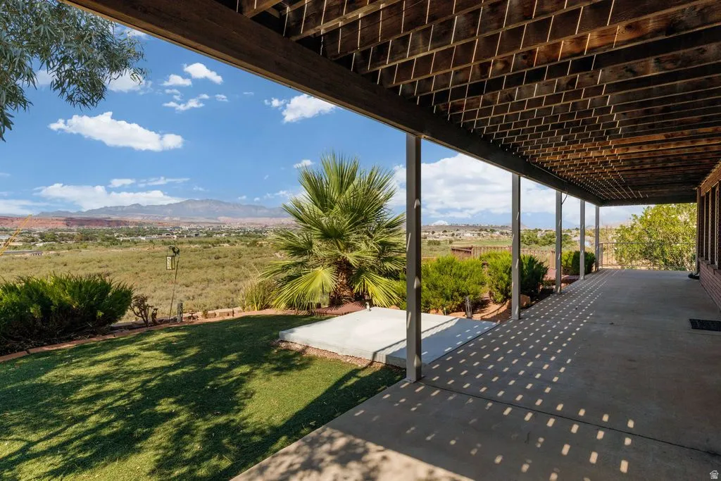 Expansive covered patio with concrete flooring, supported by multiple columns