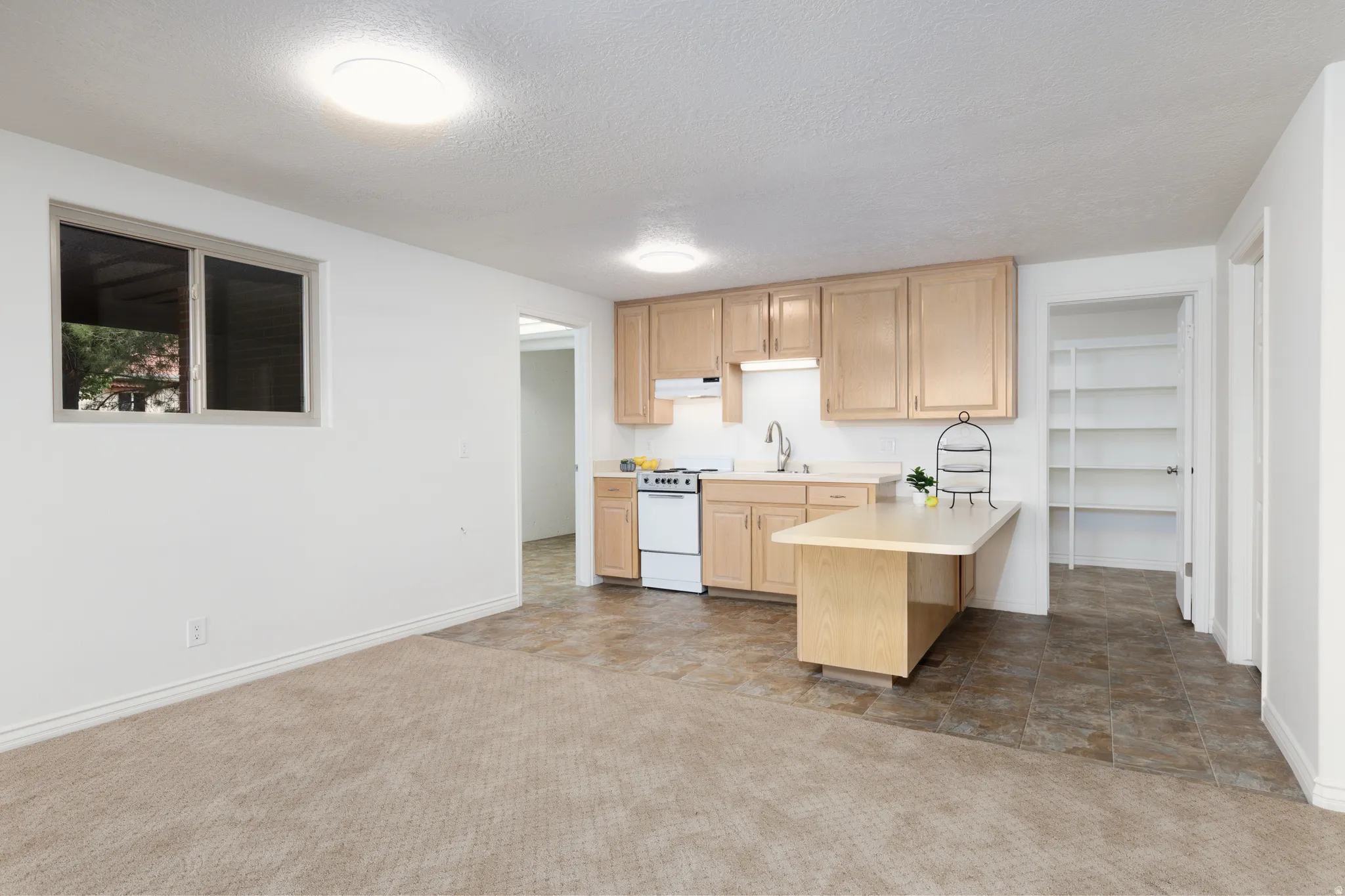 Kitchenette with wood-finish cabinetry, white appliances, and a built-in peninsula