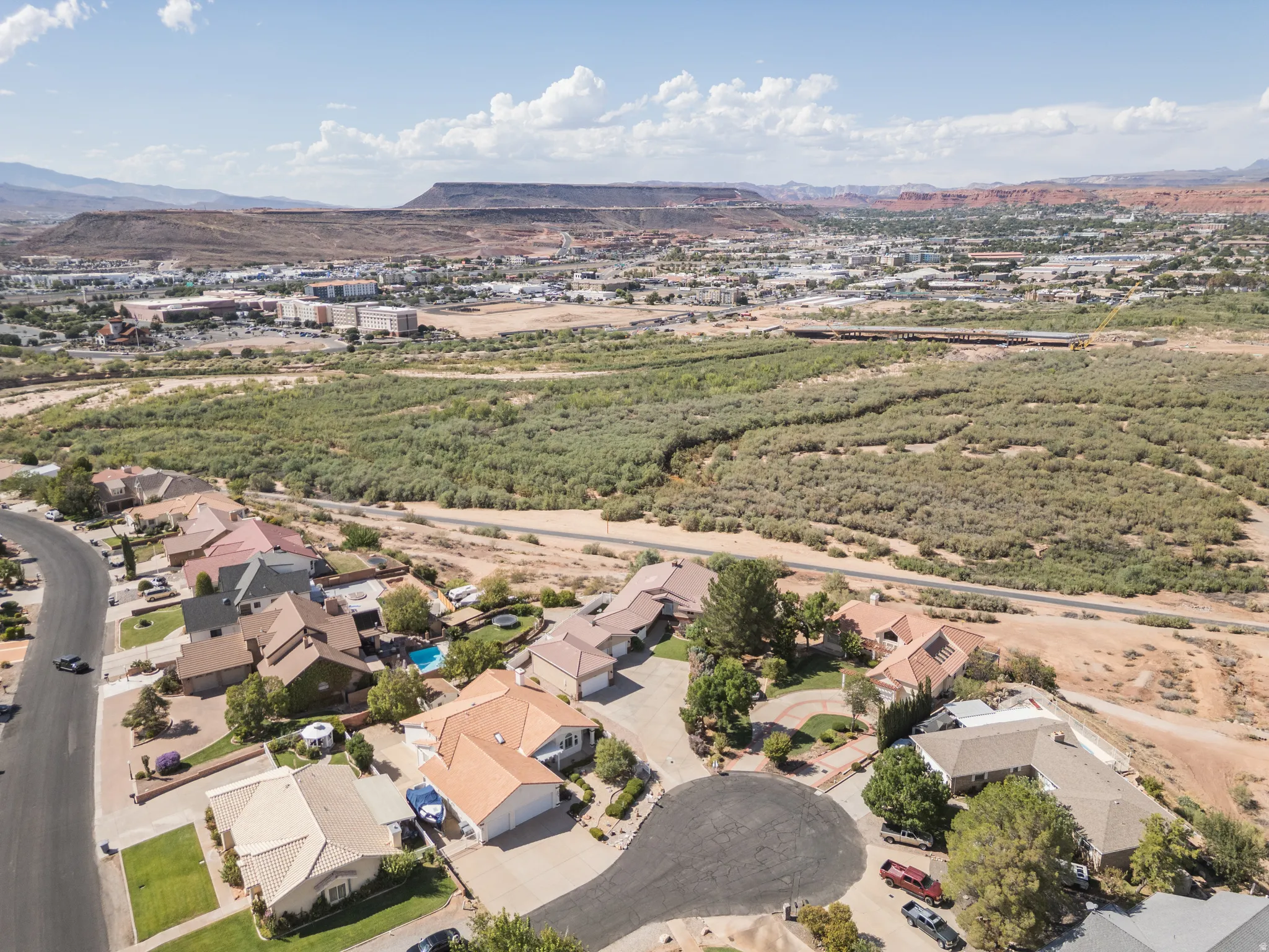Residential neighborhood with a cul-de-sac, surrounded by natural desert landscaping and distant mountain ranges