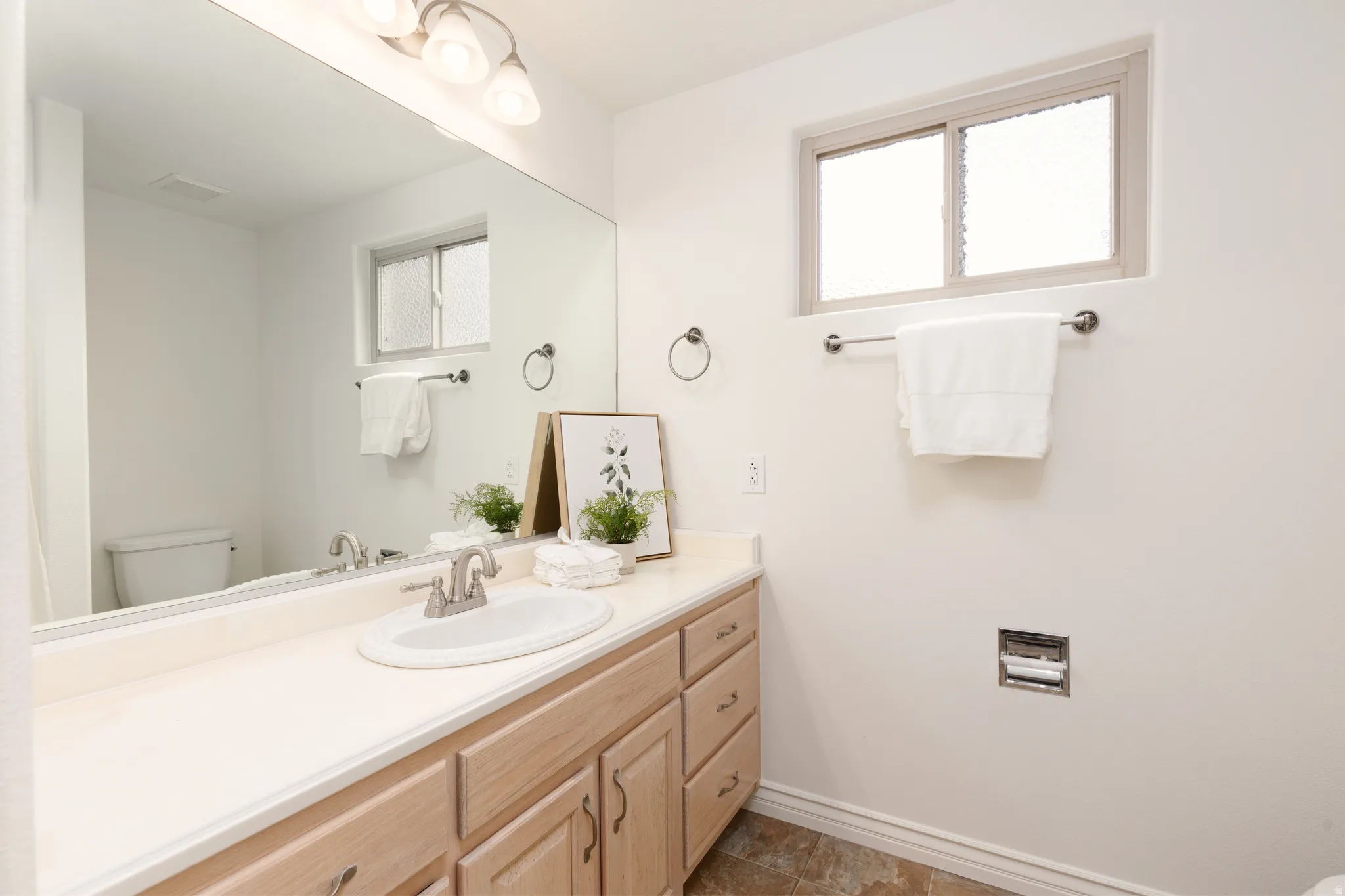 Integrated vanity with an oval basin sink and brushed nickel faucet
