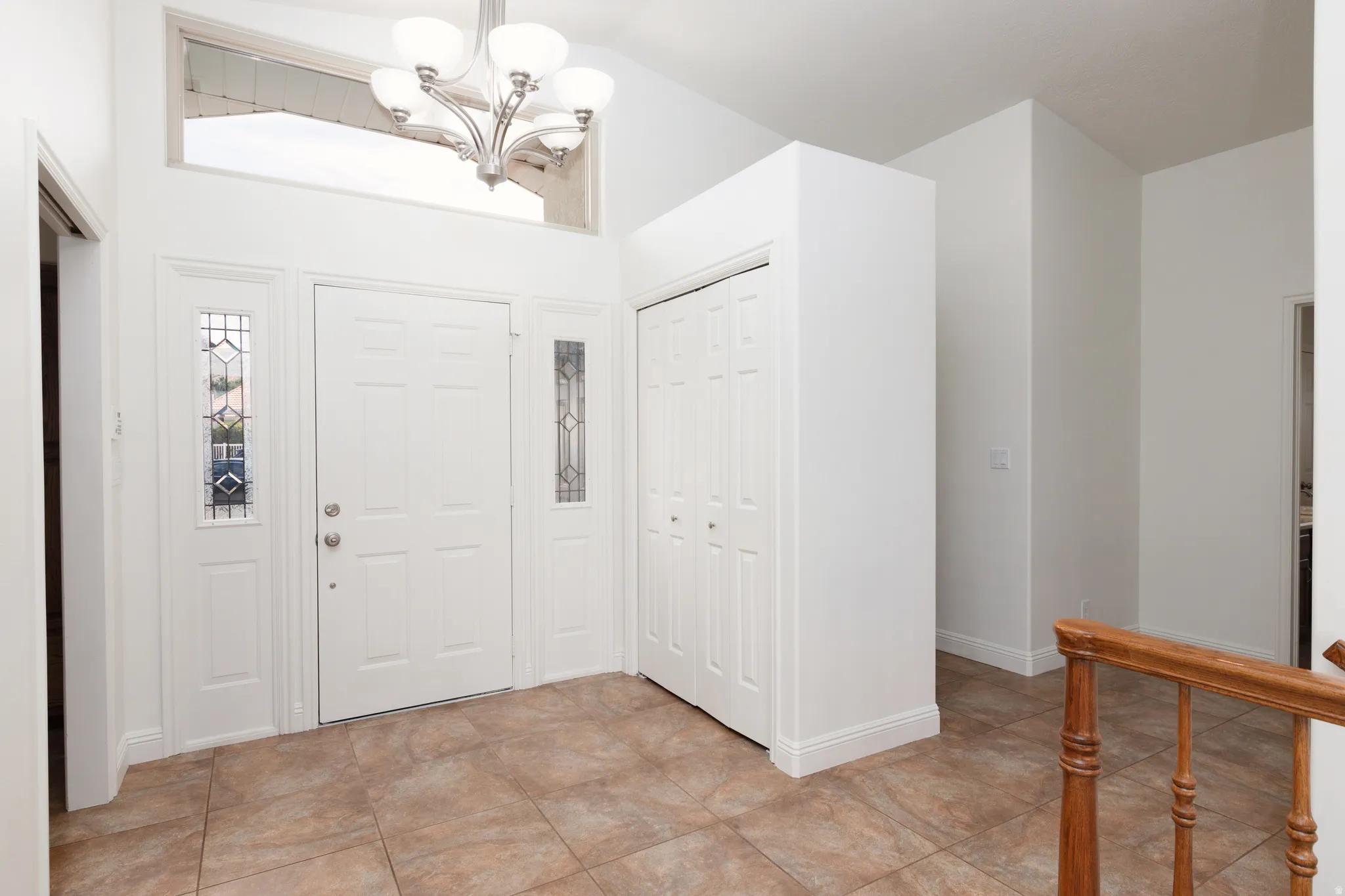 Entryway featuring a decorative transom window and sidelight panels