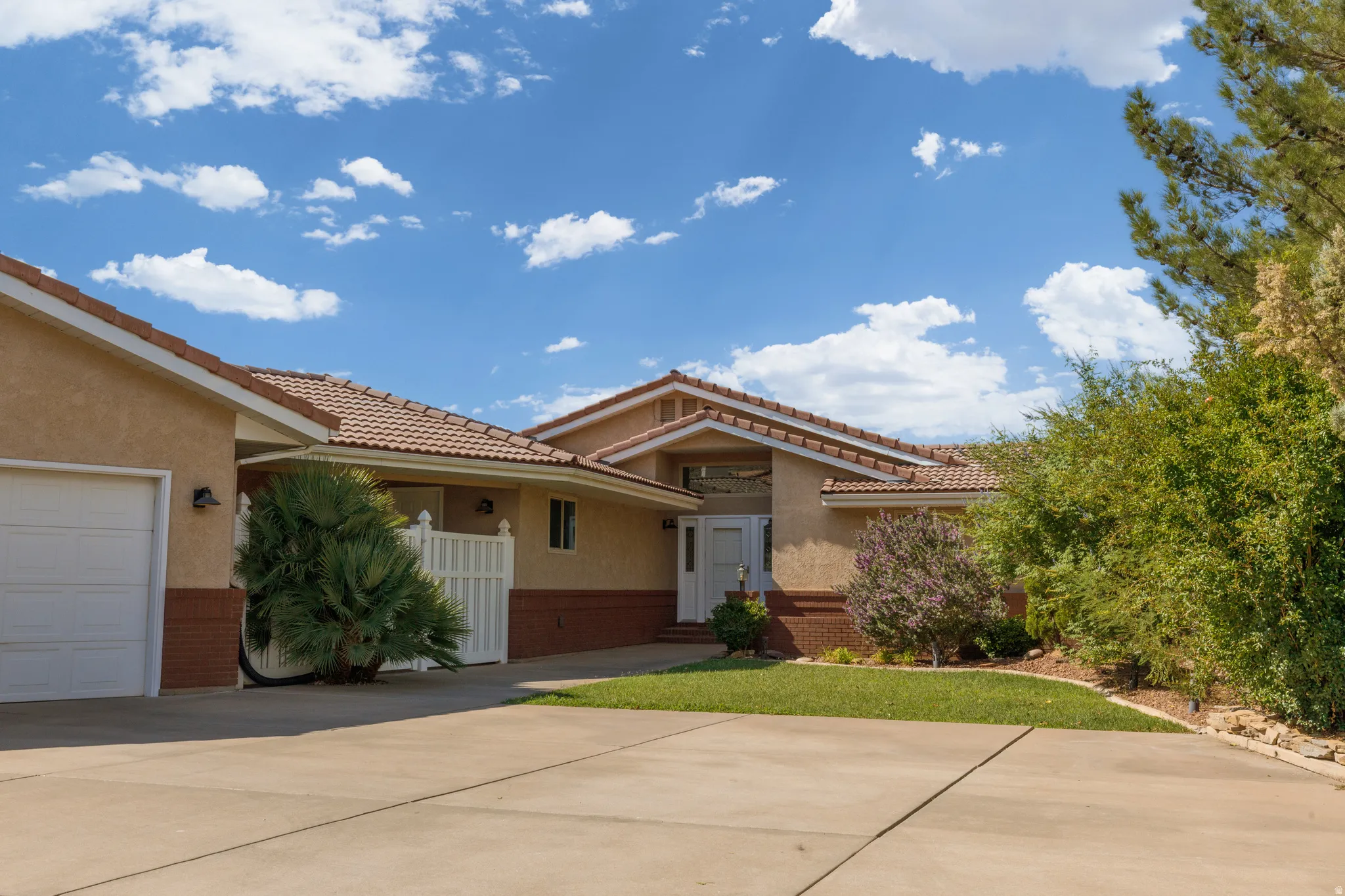 Stucco exterior with brick detailing and a tile roof