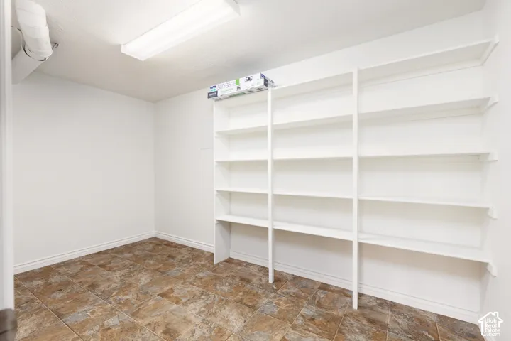 Built-in shelving units, recessed ceiling light, and tiled flooring