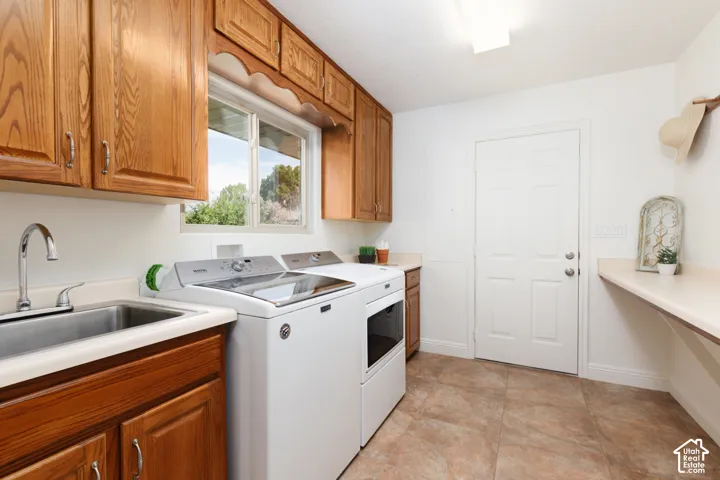 Laundry room featuring wood-finish cabinetry, a utility sink with a chrome faucet, a functional window, and a built-in wall shelf