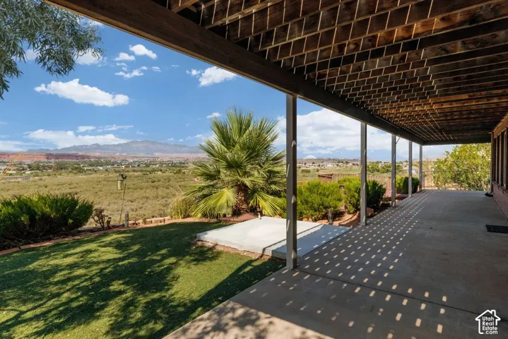 Expansive covered patio with concrete flooring, supported by multiple columns