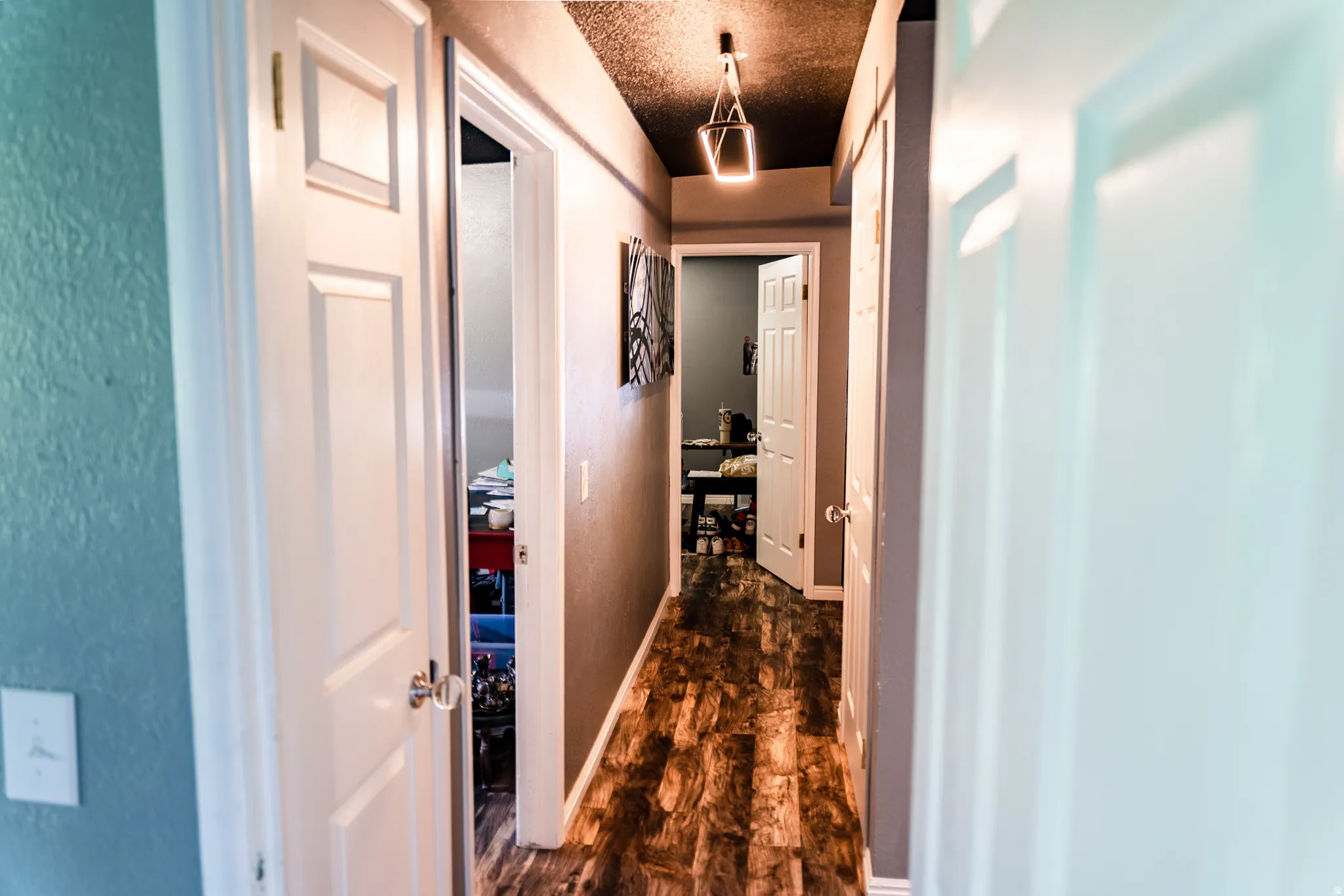 Hallway featuring wood-finish flooring and multiple paneled doors