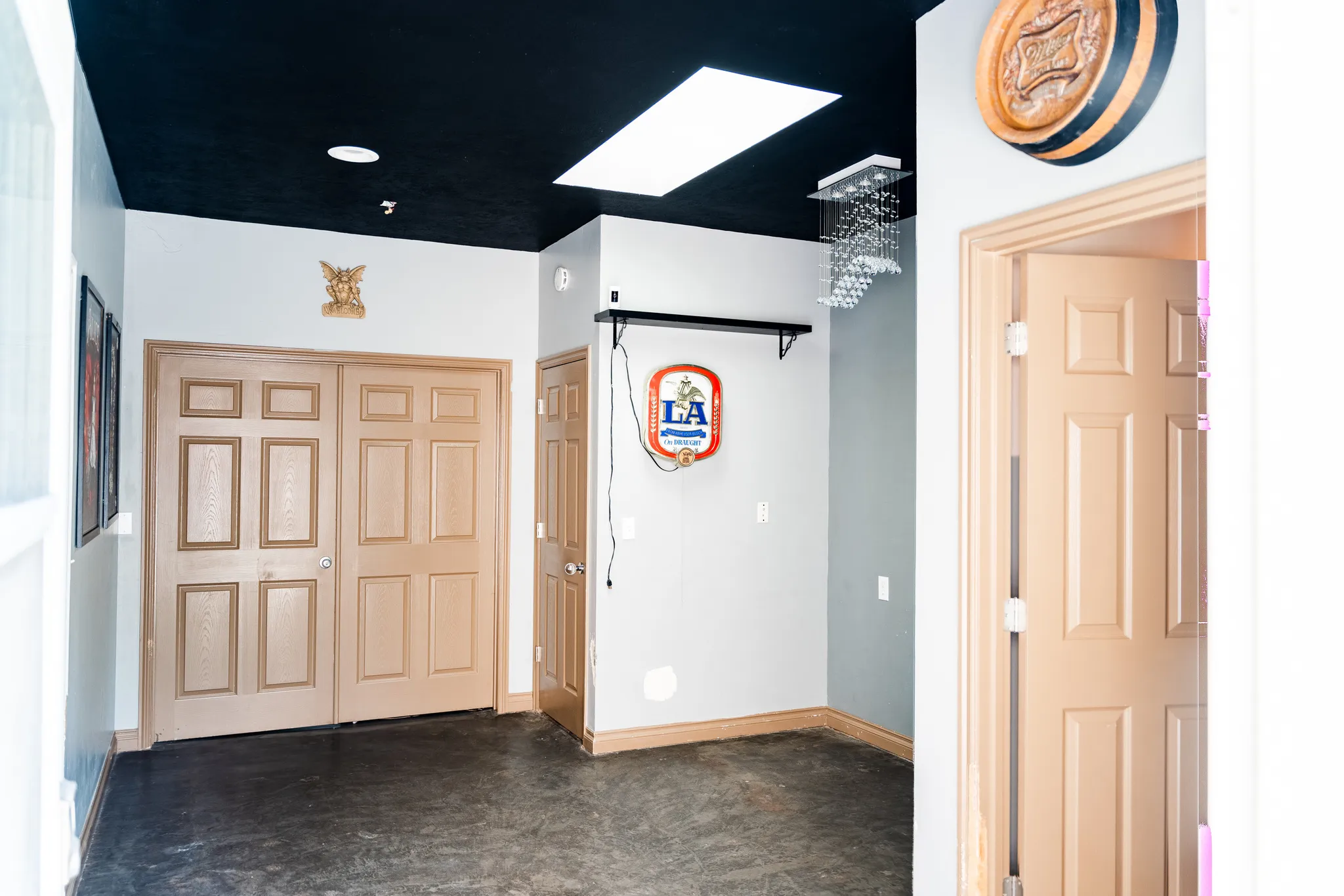 Recessed lighting, skylight, dark ceiling, gray wall accents, and panel doors