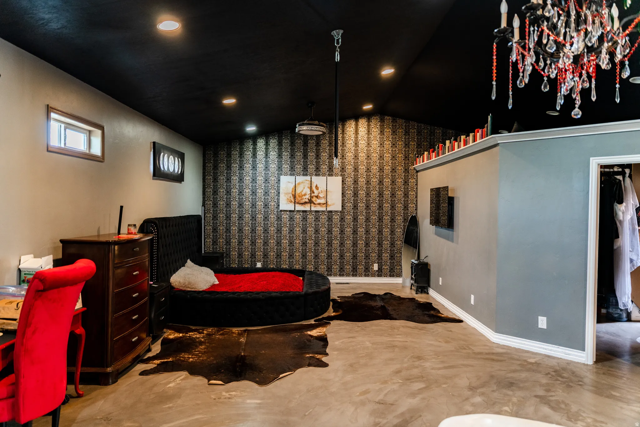 Vaulted ceiling with recessed lighting, patterned accent wall, concrete flooring, and built-in closet space