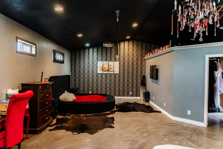Vaulted ceiling with recessed lighting, patterned accent wall, concrete flooring, and built-in closet space