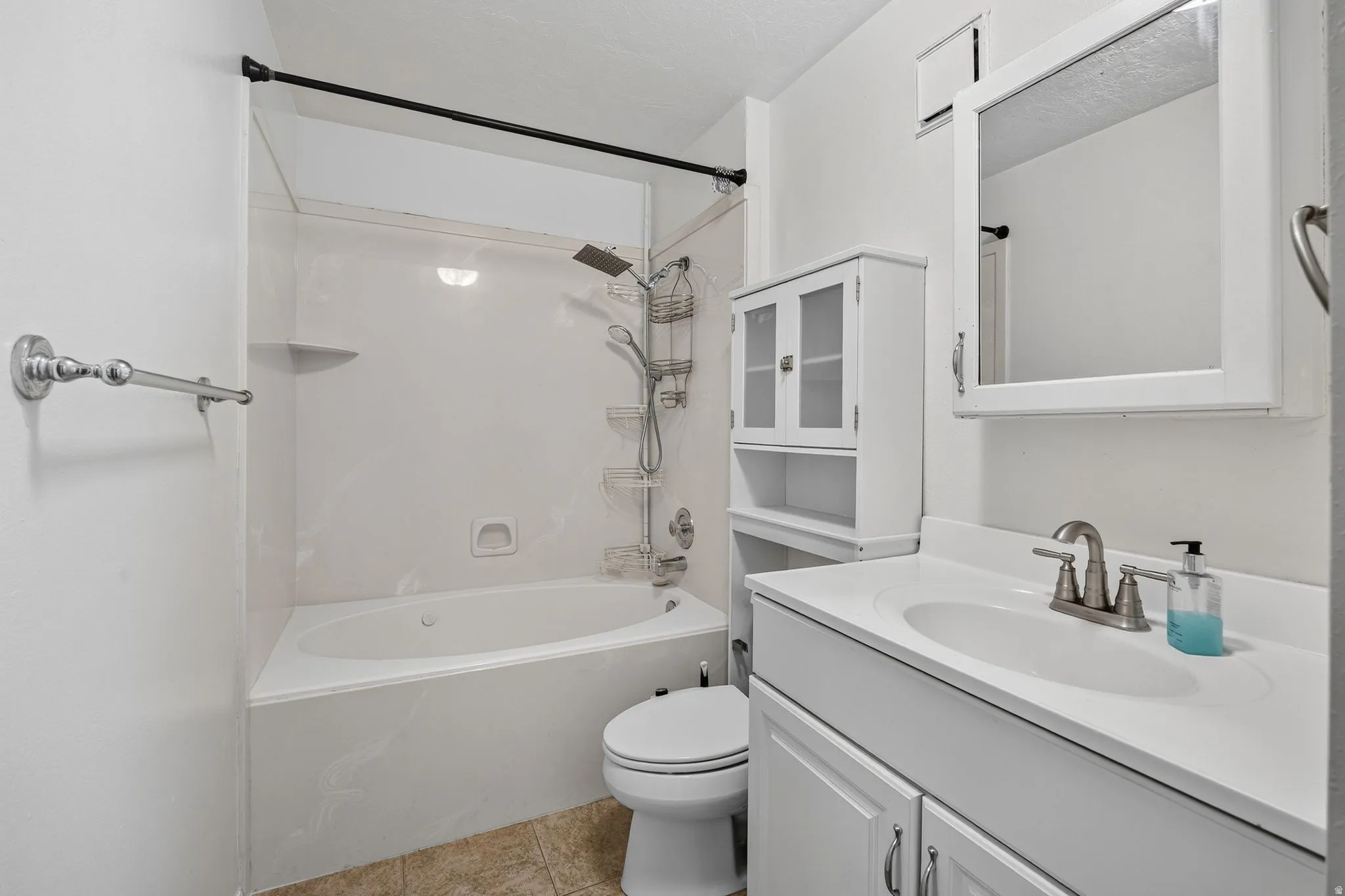 Built-in bathtub with shower, single vanity with integrated sink, white cabinetry, and white wall-mounted medicine cabinet
