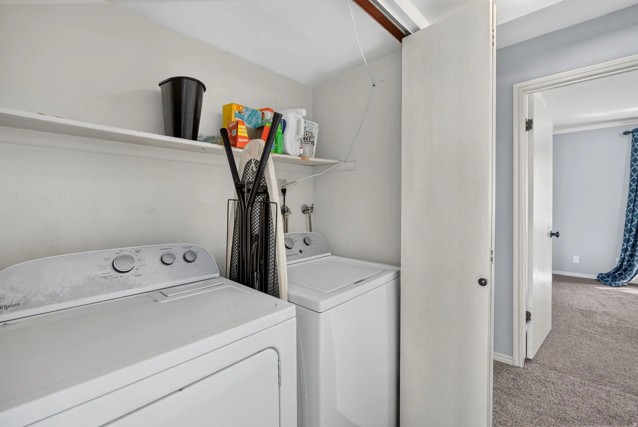 Dedicated laundry area with upper shelving for storage