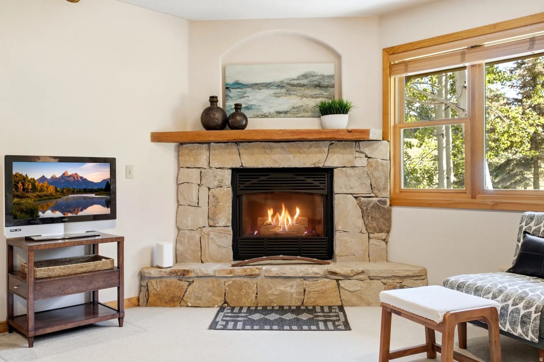 Stone-clad fireplace with a wood mantel and arched alcove