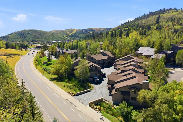 Architectural stone residence nestled on expansive grounds surrounded by mature evergreen and deciduous trees