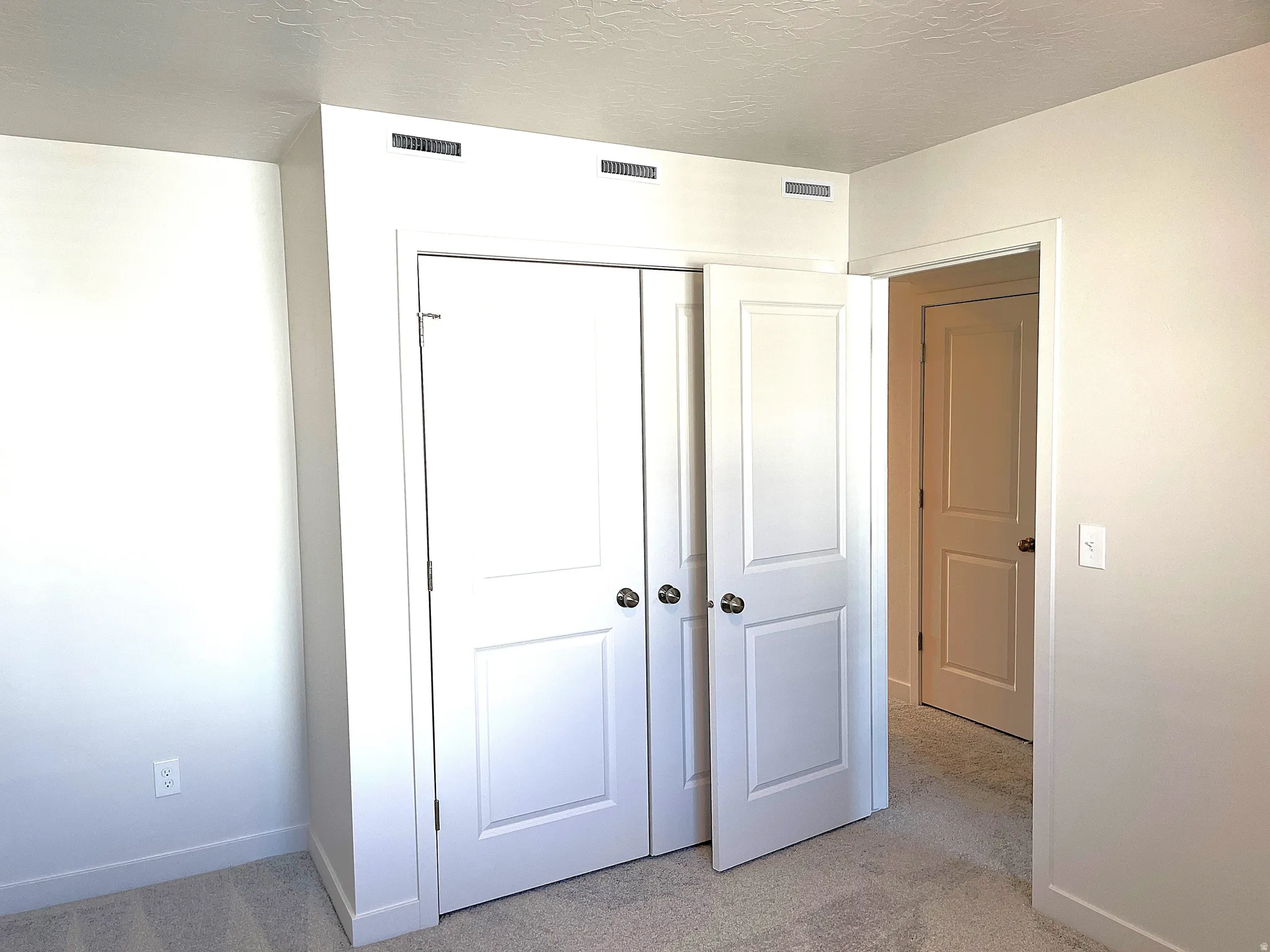 White painted walls with light-toned carpeting
