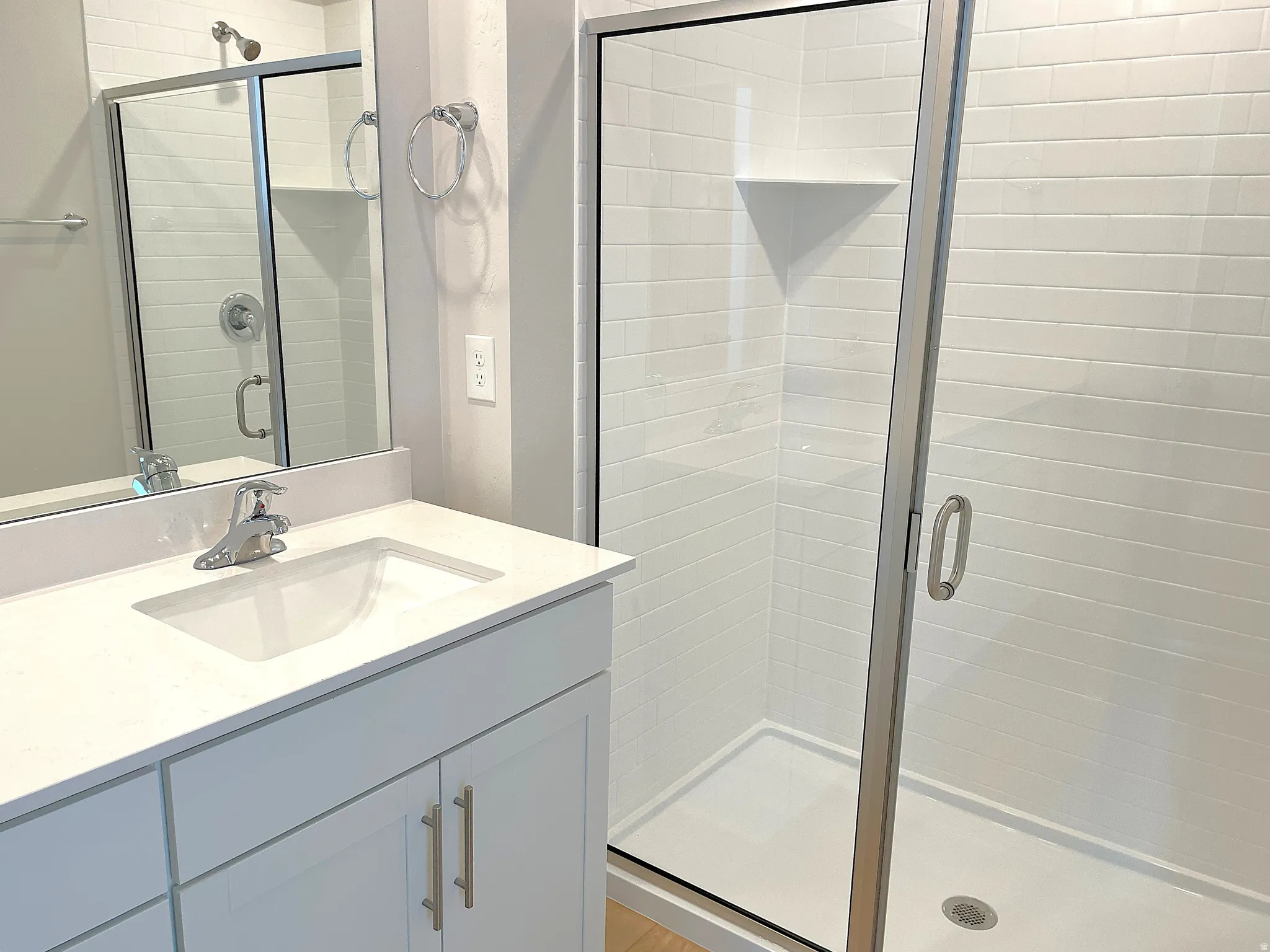 Vanity with a rectangular undermount sink, a chrome faucet, and white cabinetry